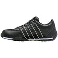 A black athletic shoe with white accents is displayed on a flat surface showcasing its sleek design and laced upper with three prominent stripes along the side