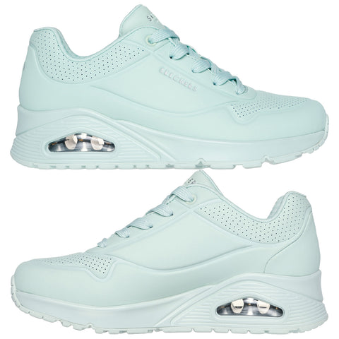 A pair of light mint-colored sneakers is displayed from two angles showcasing their smooth design breathable perforations and visible air cushioning in the sole for comfort and support