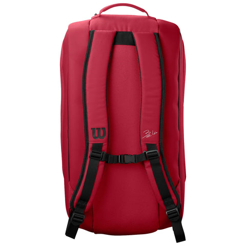 A red backpack with a sleek design features padded shoulder straps and a carry handle the brand logo is visible on the side along with a signature indicating personalization.