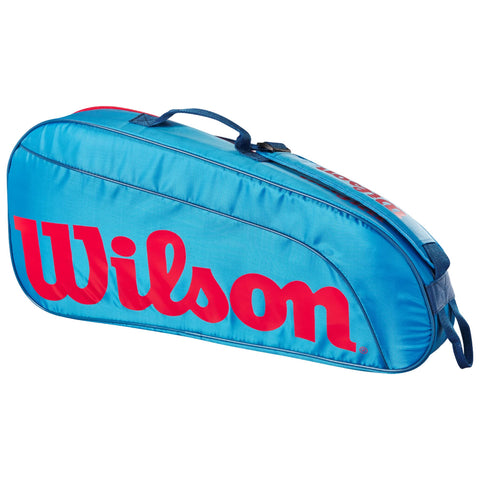 A blue sports bag with a prominent red "Wilson" logo rests on a flat surface its design is aerodynamic and features a carrying handle and zipper for securing equipment.