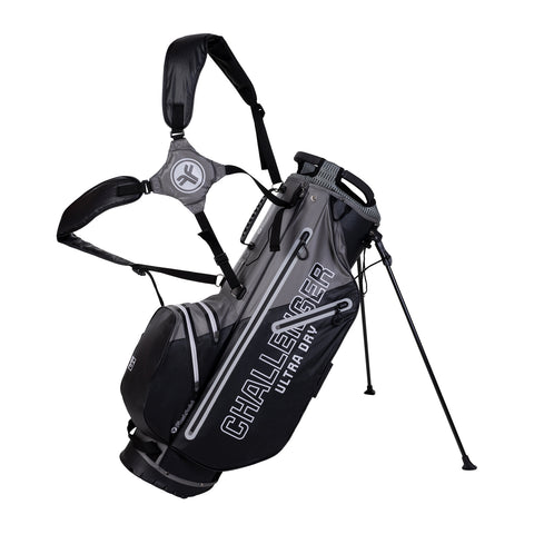 A golf bag stands upright featuring a sleek black and gray design with the text "CHALLENGER ULTRA DRY" prominently displayed it has multiple pockets and adjustable straps for convenience in a golfing context.