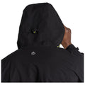 A person is wearing a black hooded jacket with an adjustable hood while touching their neck, set against a plain background emphasizing the jacket's features.