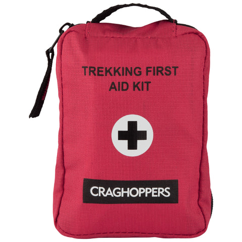 A compact red first aid kit is displayed prominently featuring the text TREKKING FIRST AID KIT and a black cross symbol along with a label reading CRAGHOPPERS on the bottom.