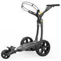 A golf cart is positioned upright with three large black wheels and a handle. The front features a curved frame for holding golf bags, ideal for transporting equipment on the golf course.