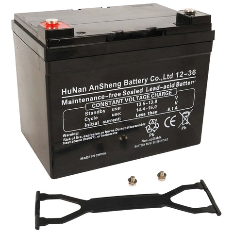 A black lead-acid battery sits upright with terminals on top while a battery strap and two screws are placed beside it in a simple, uncluttered environment. Labels indicate specifications and warnings.