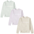 Three sweatshirts in pastel colors are displayed with the word Humanrace prominently printed in white across the front each featuring a round neckline and long sleeves against a plain white background.