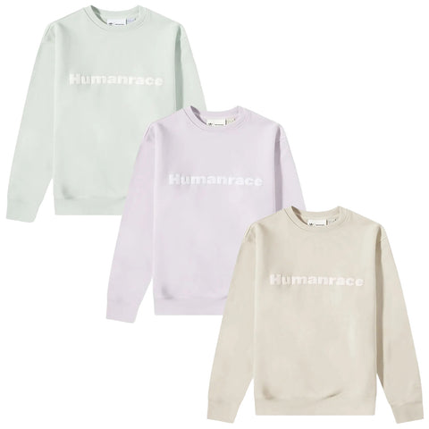 Three sweatshirts in pastel colors are displayed with the word Humanrace prominently printed in white across the front each featuring a round neckline and long sleeves against a plain white background.