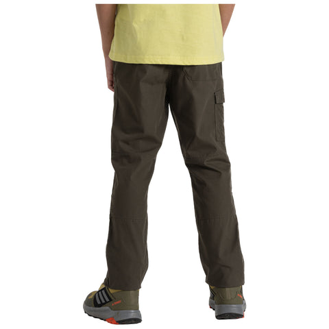 A person stands with their back facing the viewer wearing green cargo pants and hiking shoes against a neutral background; their short-sleeved yellow shirt is partially visible.