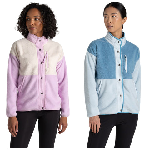 Two women stand side by side wearing colorful fleece jackets. One jacket is in shades of pink and white while the other features blue tones. Both have high collars and buttons.