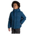 A child stands confidently wearing a blue puffer jacket with a hood showcasing a slight smile while posing against a plain white background.