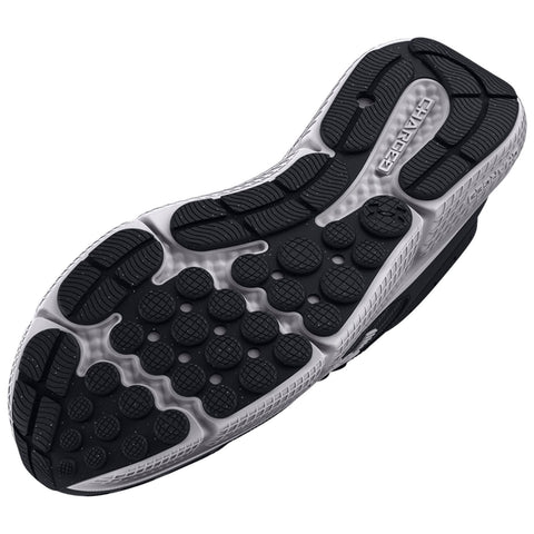 A shoe sole featuring a textured pattern with various shapes for traction rests on a flat surface highlighting the design intended for grip and support during walking or running activities.