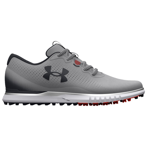 A grey athletic shoe features a textured upper with perforations and a black logo. It has a cushioned sole with visible traction studs, suitable for outdoor sports activities.