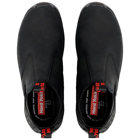 Black footwear featuring a slip-on design rests flat. The shoes display a sleek profile with red branding inside, intended for durability and comfort in various environments.