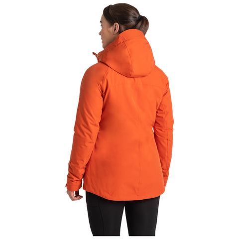 A woman wears an orange hooded jacket while standing in a neutral background facing slightly away from the viewer showcasing the jacket's design and color.