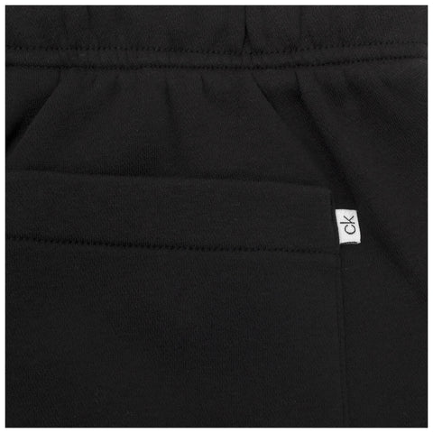 A black garment features a small pocket and a brand tag on the side creating a simple yet stylish design suitable for casual wear.