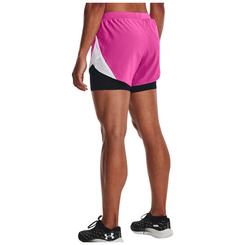 A person stands wearing pink athletic shorts with a black base and light detailing along the sides. They are in a neutral or indoor setting, likely preparing for physical activity.