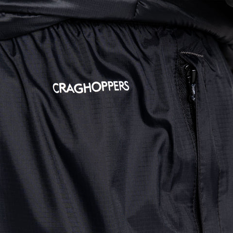 A black fabric garment displays the logo CRAGHOPPERS prominently while featuring a zippered pocket that suggests functionality and utility in an outdoor or casual setting.