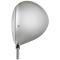 A golf driver head rests upright featuring a sleek metallic surface with green accents and grooves designed for striking a golf ball in an outdoor sporting environment.