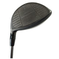 A golf club head featuring a black finish and a textured striking surface is displayed at an angle with adjustable settings indicated by letters D and S on the shaft.