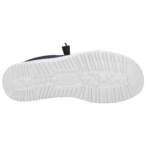 A shoe sole is positioned upwards displaying a textured white rubber surface with grooves and treads the shoe appears to be part of a casual footwear style.