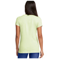 A light green short-sleeve shirt is displayed from the back with a simple design while being worn by a person in blue leggings in a neutral background.