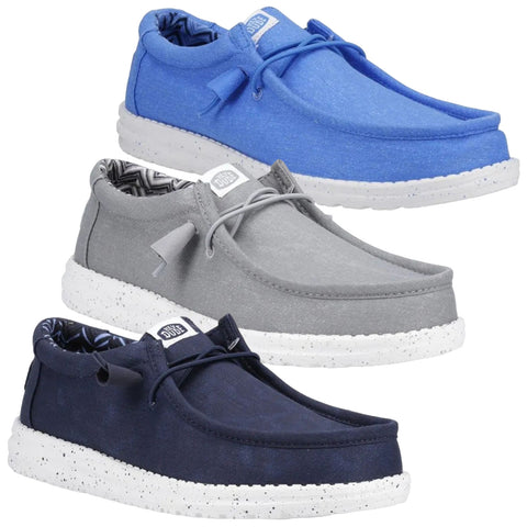 Three pairs of casual shoes are displayed in a stacked arrangement. The shoes feature a rounded toe a lace-up design and a speckled rubber sole. They are in blue gray and navy colors.