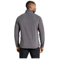 A person wearing a gray fleece pullover is standing with their back turned. They appear to be in a neutral background, likely indoors. Their posture is relaxed.