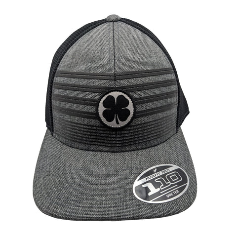 A gray snapback hat features a black four-leaf clover emblem on the front and has a textured fabric design with a flat brim surrounded by a black mesh.