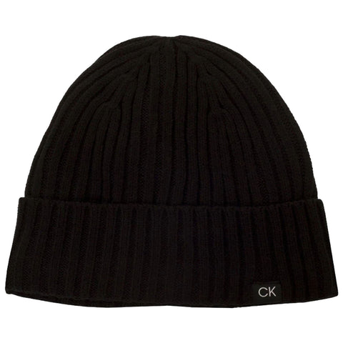 A black knitted beanie sits upright highlighting its ribbed texture the folded brim features a small label with the letters CK indicating the brand.