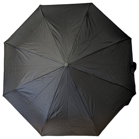 A black umbrella is opened wide showcasing its dome-shaped canopy and structural ribs while resting flat on a surface with a neutral background providing no additional context or distractions.