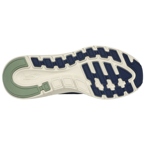 A sneaker sole is displayed featuring a patterned rubber tread design with traction grooves and a green accent on the heel area situated against a plain white background.