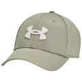 A green baseball cap made of fabric featuring a white Under Armour logo sits angled to the side showcasing its curved brim and structured crown in a neutral setting