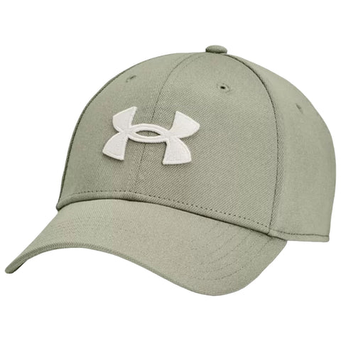 A green baseball cap made of fabric featuring a white Under Armour logo sits angled to the side showcasing its curved brim and structured crown in a neutral setting