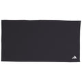 A black exercise mat lies flat on a surface with a distinctive white Adidas logo in one corner providing a simple yet functional space for workouts or yoga practices.