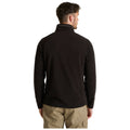 A person wearing a black fleece jacket stands with their back facing the viewer in a neutral, well-lit environment, showcasing the garment's design and fit without any visible expressions or actions.