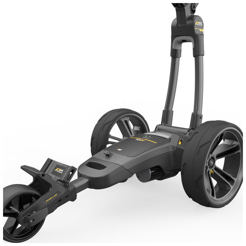 A black golf push cart with large wheels is positioned upright showcasing its sleek design and features for easy maneuverability on a golf course or practice area.