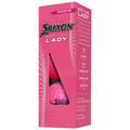 A pink box displays two golf balls labeled Srixon Soft Feel Lady showcasing product features like softer feel and long distance along with technical specifications on the side.