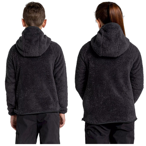 Two children stand back to back wearing dark fleece hoodies with hoods up in a plain white background conveying a casual and comfortable winter attire look.