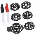 A set of black stencils with various letters and symbols is displayed alongside two pens one black and one red in a neutral background, ready for creative use.