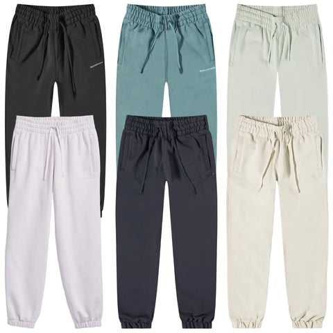 Five pairs of casual jogger pants in various colors are displayed side by side with elastic waistbands and pockets highlighting their comfortable design suitable for leisure or active wear.