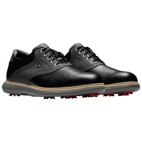 FootJoy Mens Traditions Golf Shoes A black leather golf shoe with a smooth finish and perforated detailing features a thick sole with red spikes for traction and a minimalistic design suitable for casual or sport use.