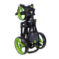 A green and black golf push cart is folded for storage the wheels are large and partly visible with a handle aimed for easy carrying in an indoor setting.