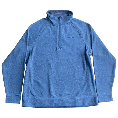 A blue pullover fleece is laid flat displaying a zippered neck and long sleeves in a textured pattern while the background is a plain white surface.