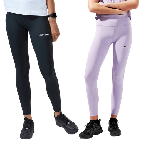 Two women are wearing fitted leggings in black and light purple while standing side by side showcasing the garments the black pair is paired with black shoes and the purple with dark shoes.