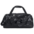 A black and gray camo duffel bag features multiple zippered compartments and a shoulder strap showing the Under Armour logo prominently. It is designed for sports or travel use.