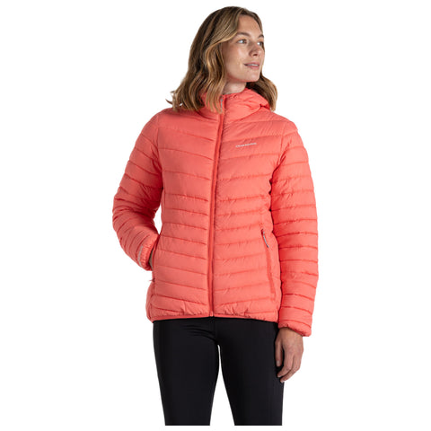 A woman is wearing a bright coral quilted jacket with a hood facing away from the viewer in a neutral background suggesting a casual outdoor or indoor setting.