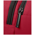 A close-up of a red fabric bag features a black zipper with a pull tab displaying a logo the zipper is partially open revealing the inner material of the bag