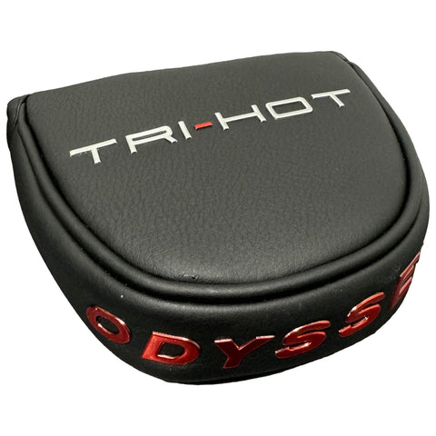 A black leather golf putter cover with embossed text reads TRI-HOT in silver and ODYSSEY in red resting on a flat surface, designed to protect the putter.