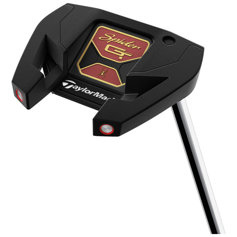 A black golf putter with a wide head and highlighted red accents sits angled upwards on a silver shaft. The brand logo TaylorMade is visible on the putter's base.