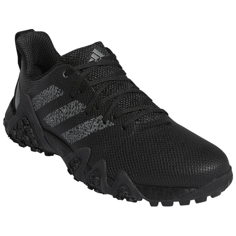 A black athletic shoe features a textured upper, three grey stripes on the side, and a rugged sole designed for outdoor traction, positioned against a plain background.